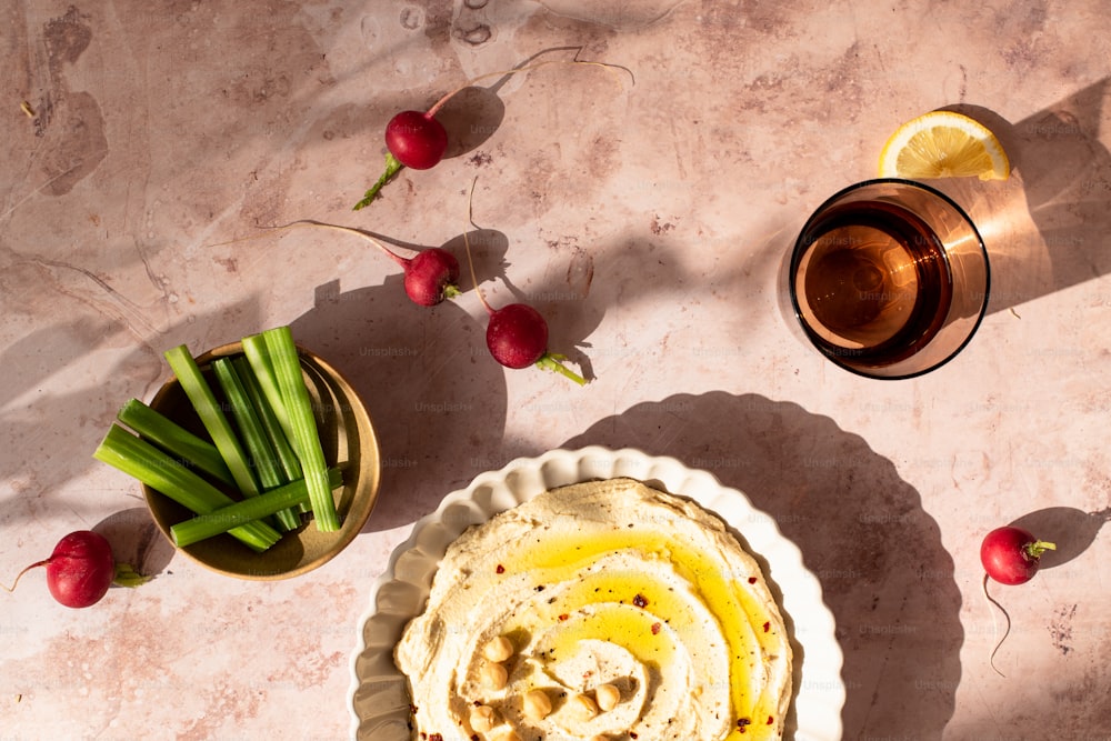 a bowl of hummus next to a bowl of radishes