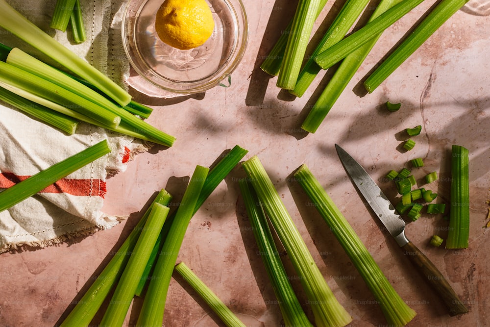 a bunch of celery sitting on top of a table next to a knife