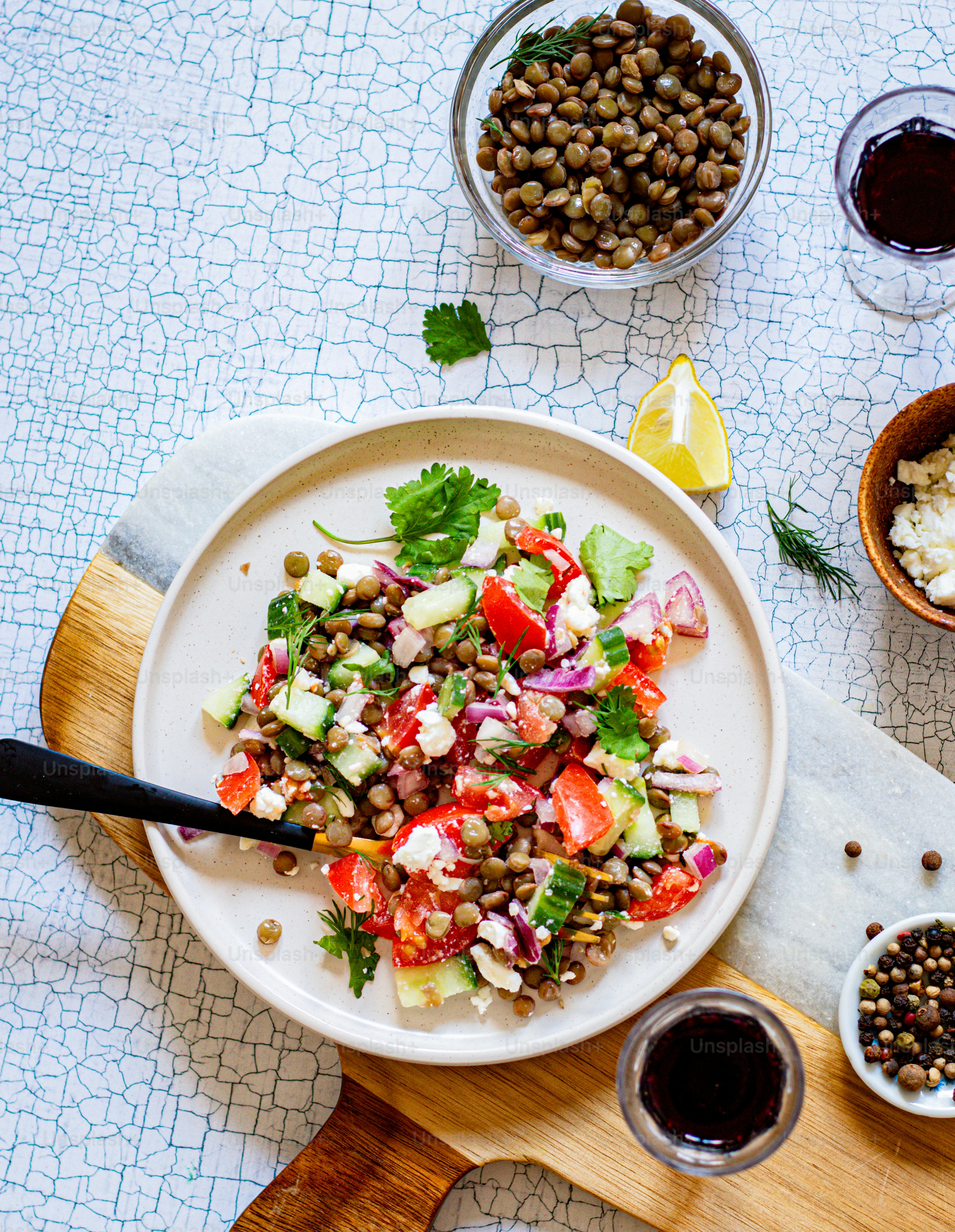 une assiette blanche garnie d’une salade à côté d’un bol de haricots