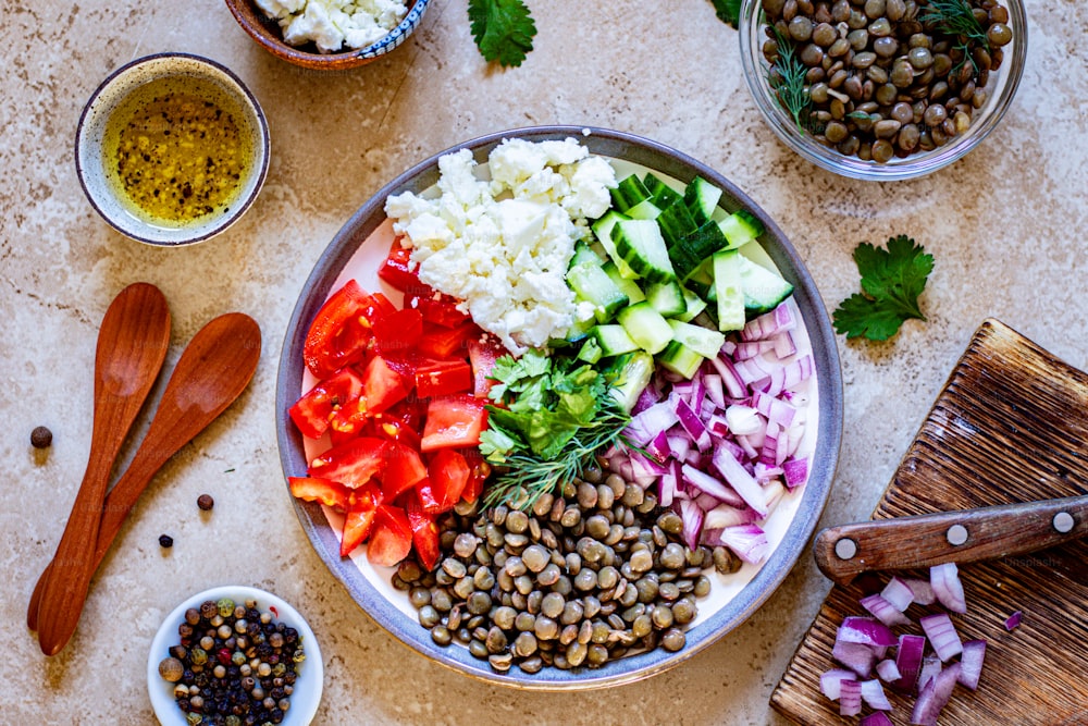 a plate of food with beans, cucumbers, tomatoes, and other ingredients