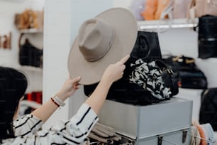 Eine Frau probiert in einem Geschäft einen Hut an
