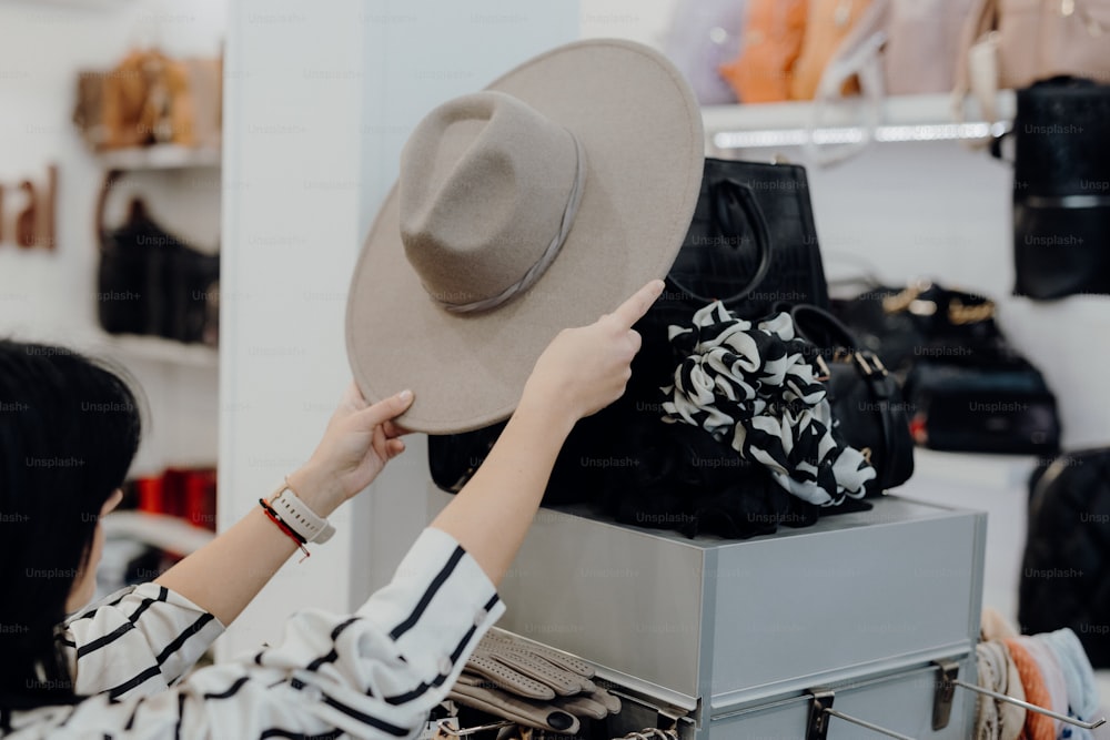 a woman is trying on a hat in a store