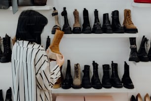 a woman standing in front of a wall of shoes