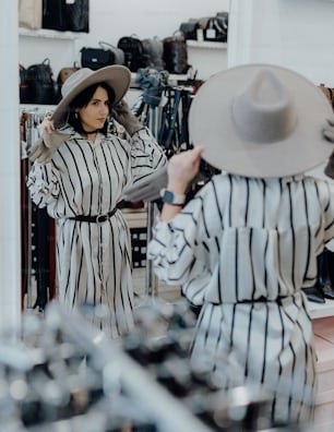 a woman in a hat looking at herself in a mirror