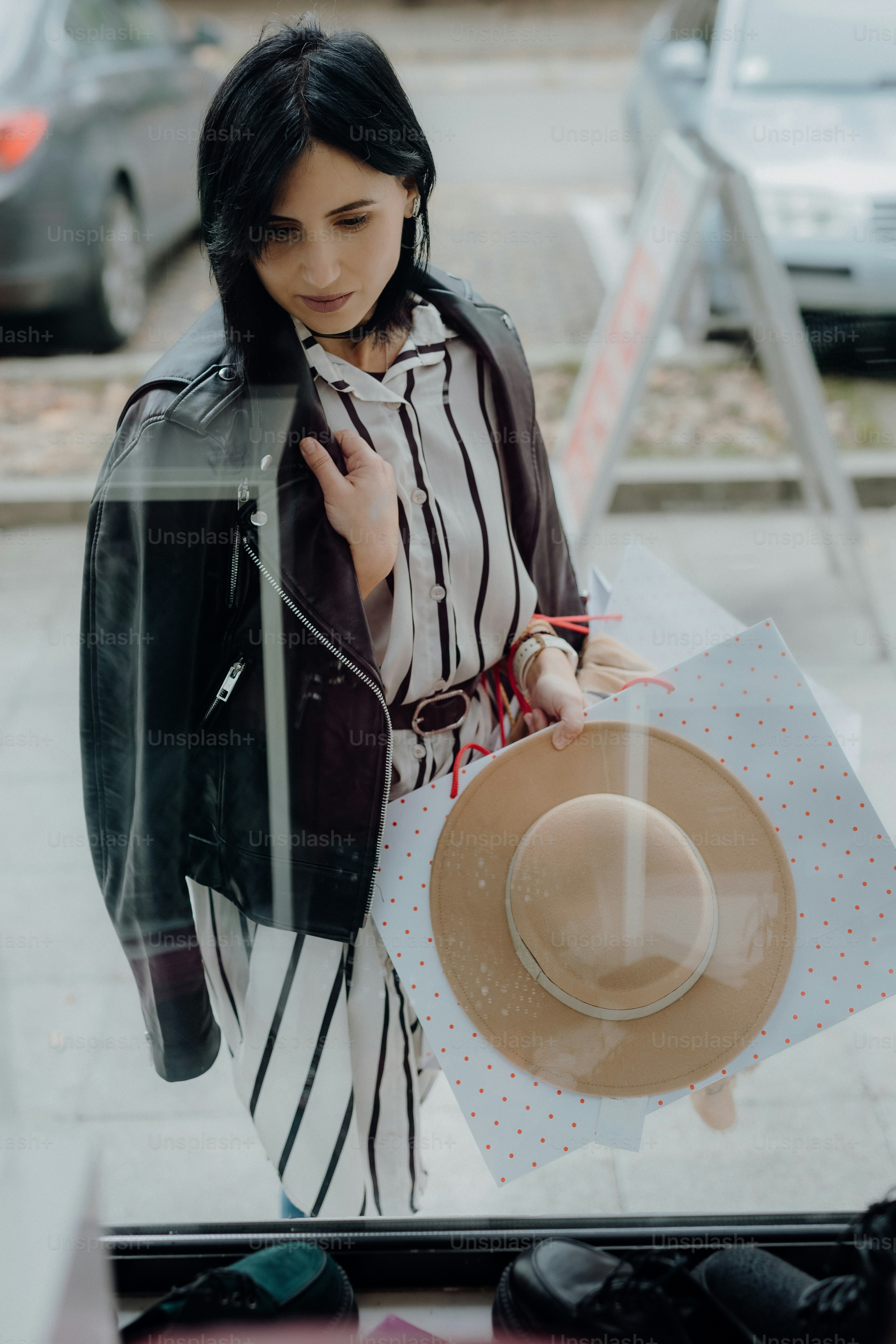 a woman looking through a window at a hat
