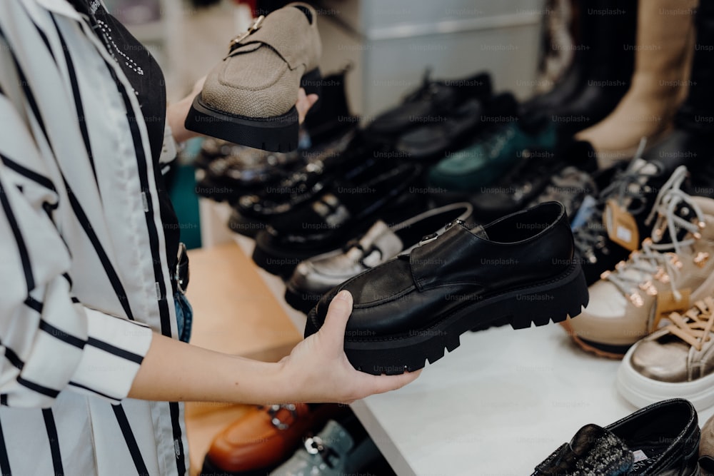 a woman standing in front of a table filled with shoes