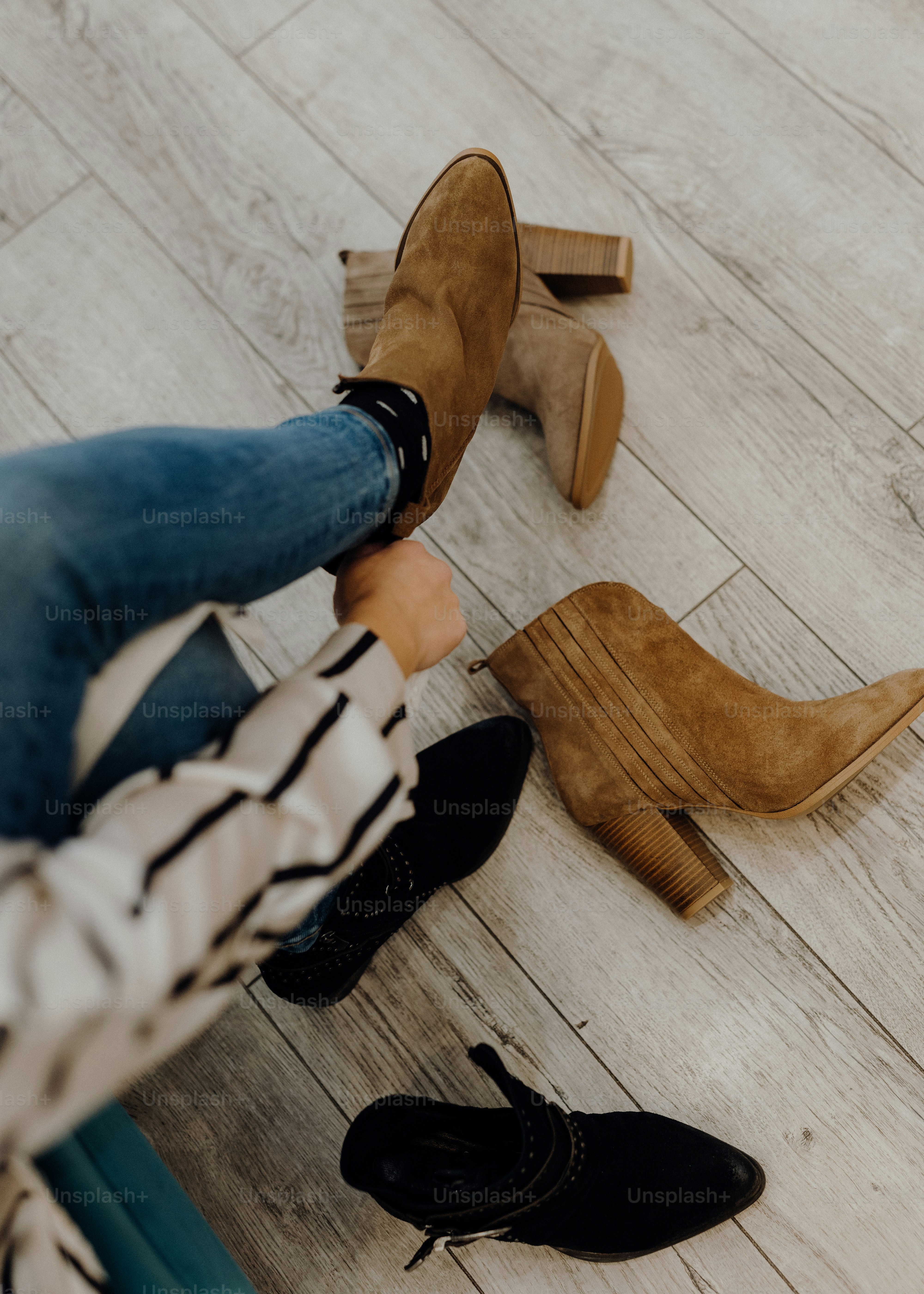 a woman sitting on the floor next to a pair of shoes