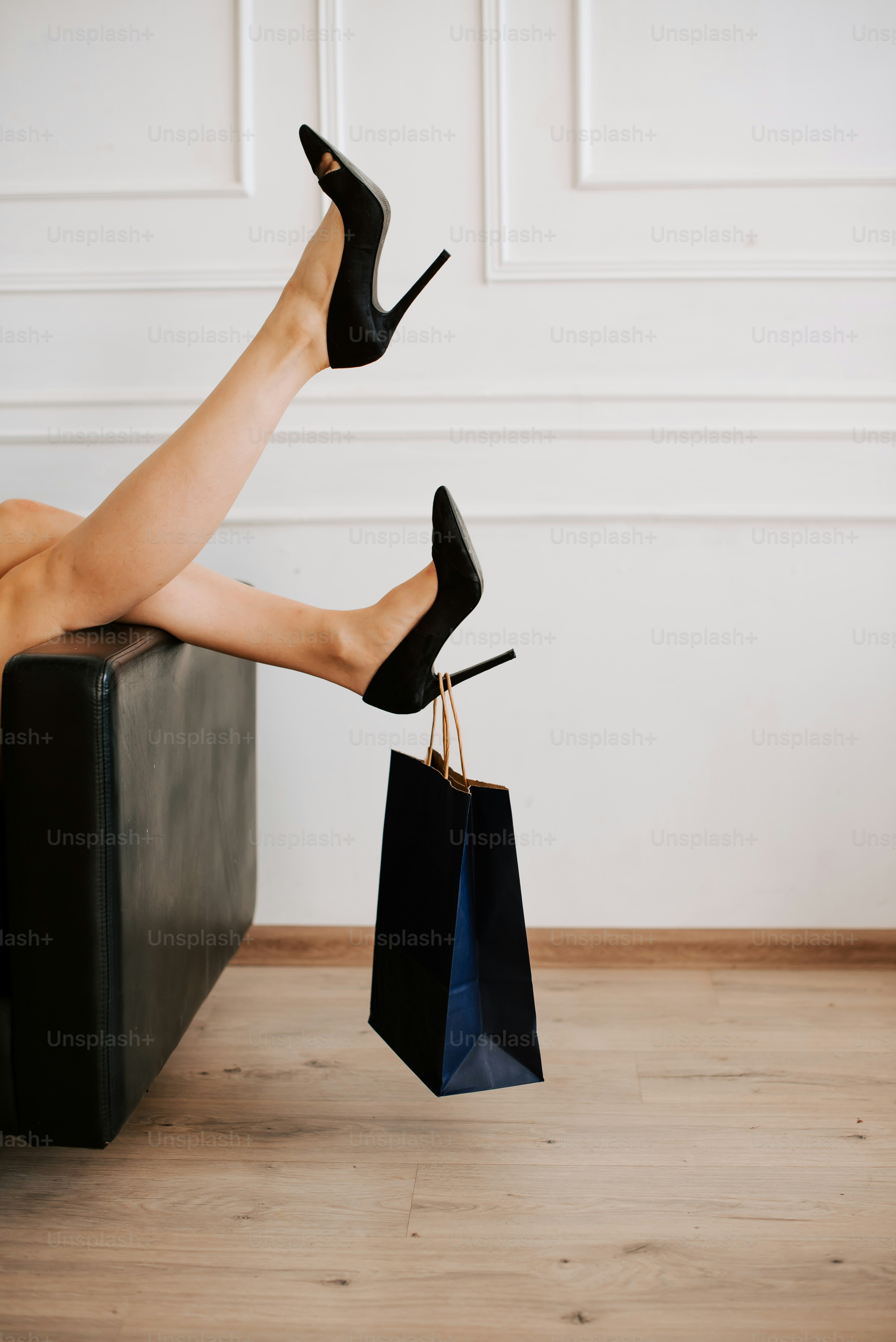 les jambes d’une femme avec des talons hauts assise sur une valise