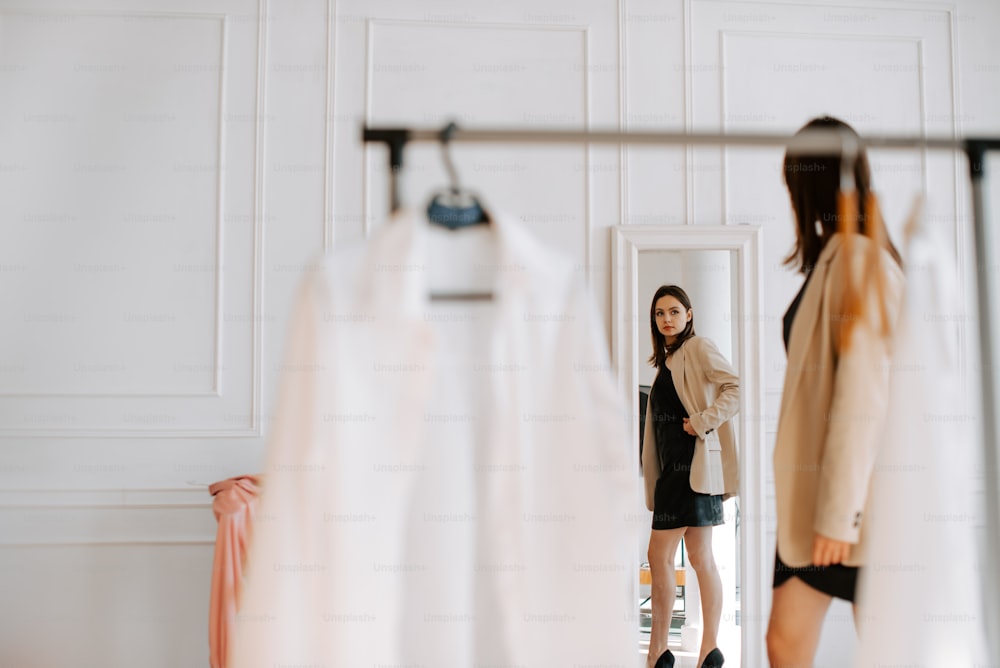a woman standing in front of a mirror in a room
