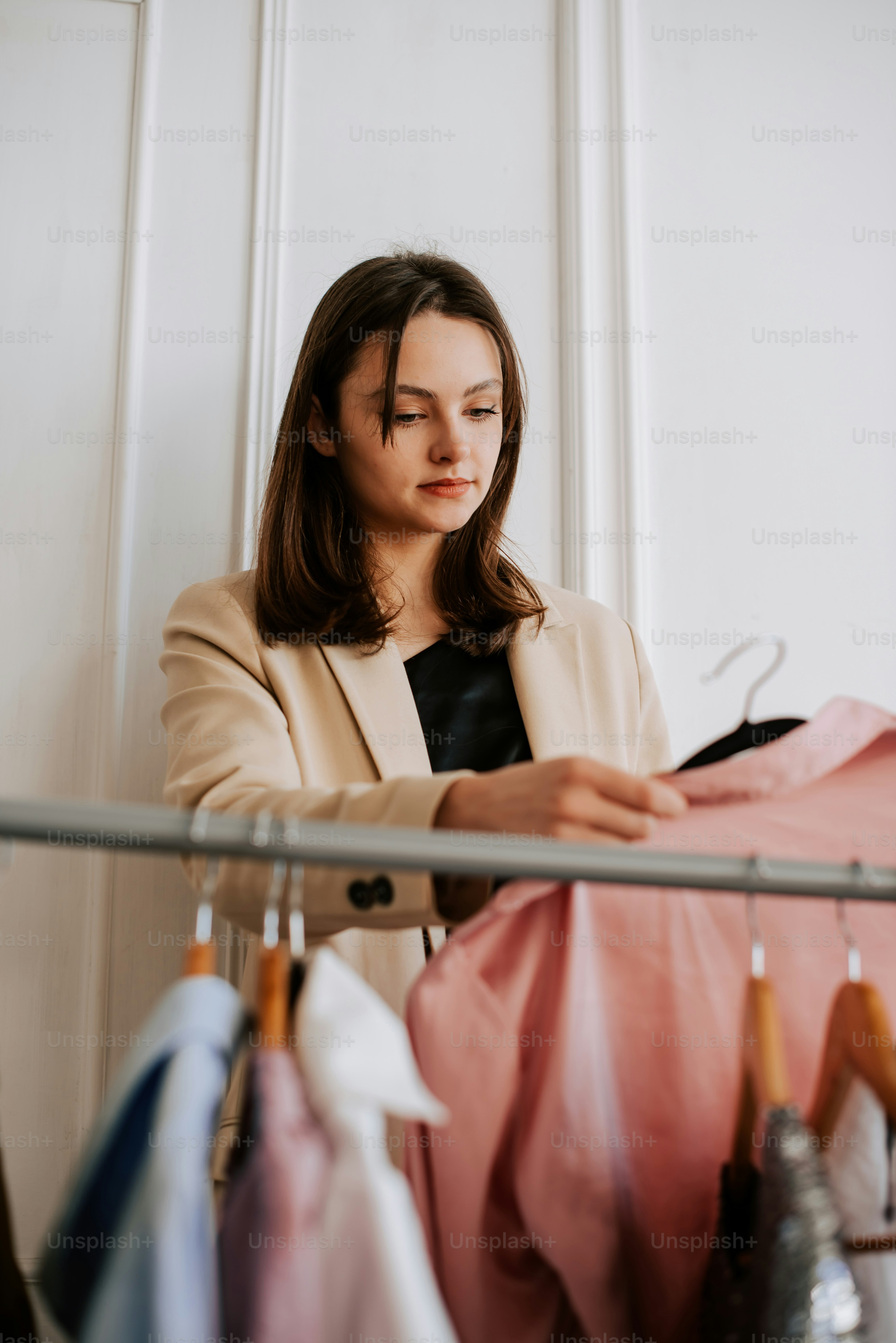 a woman is looking at clothes hanging on a rack