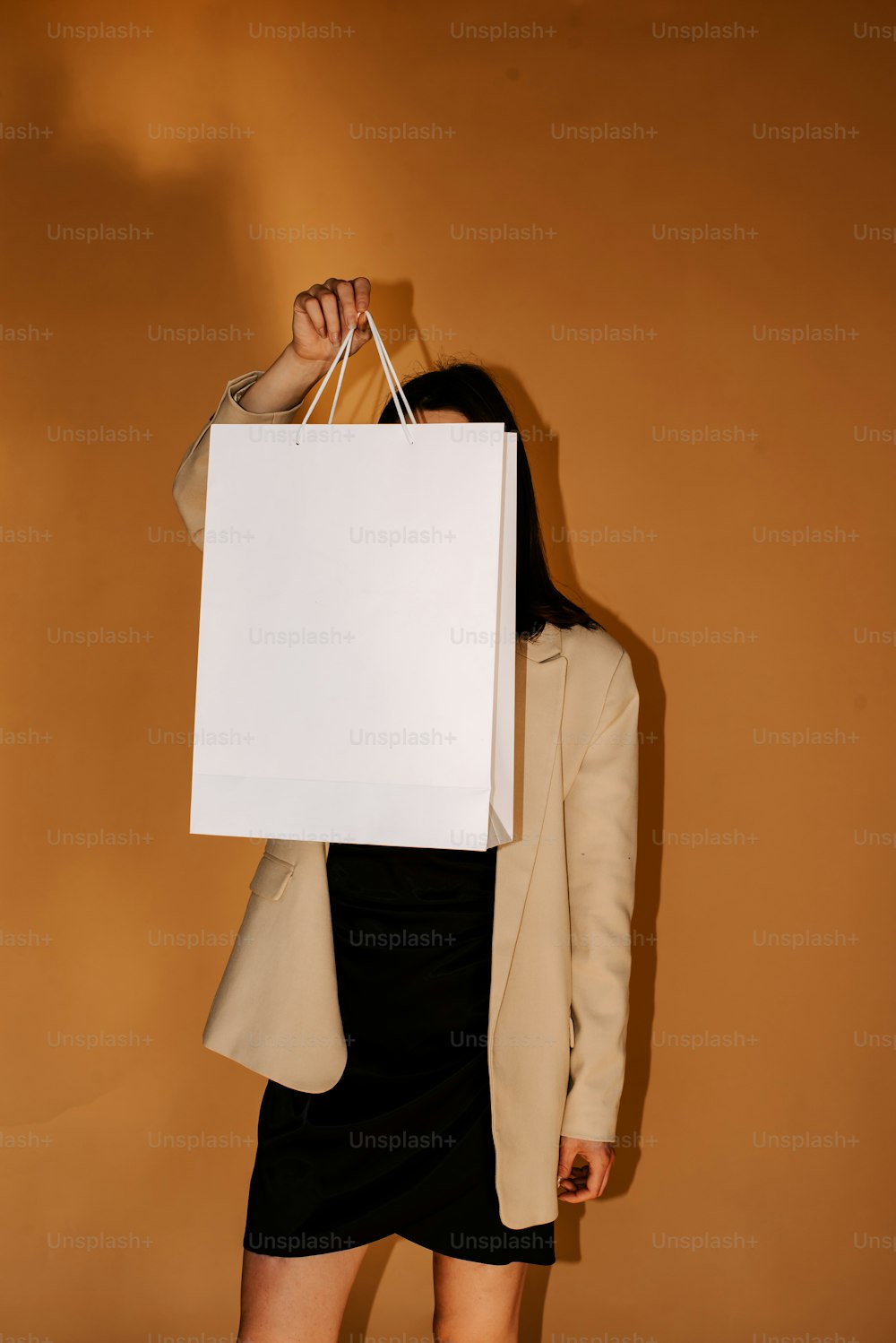 a woman holding a white shopping bag in her hands