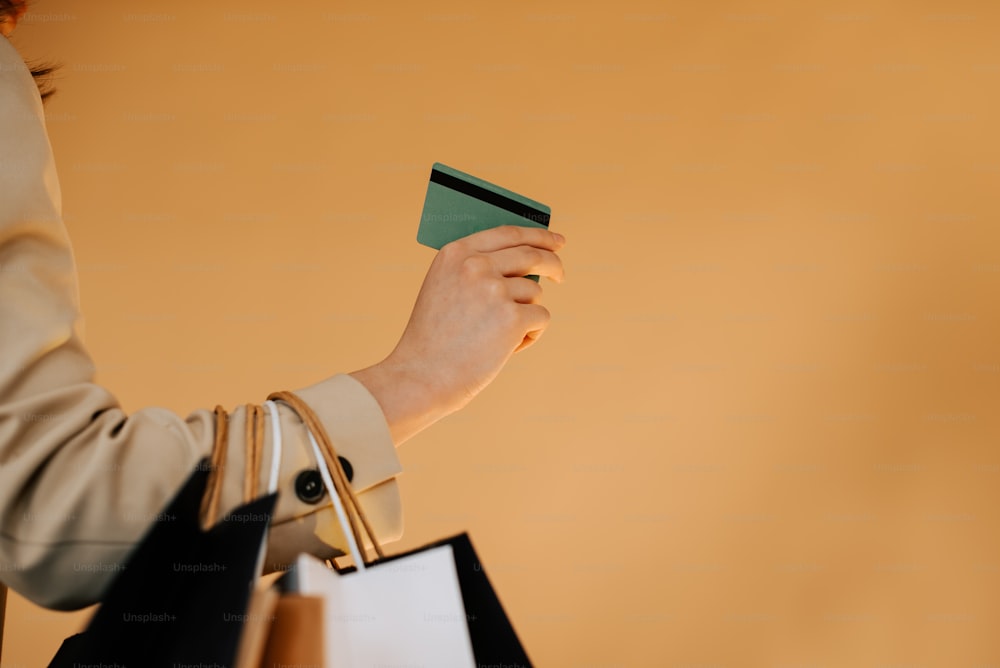 una mujer sosteniendo una tarjeta de crédito y una bolsa de compras