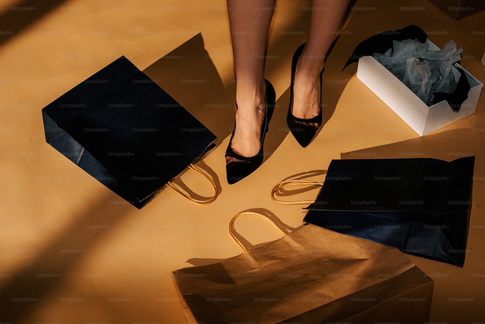los pies de una mujer con un par de zapatos negros de pie sobre una mesa con