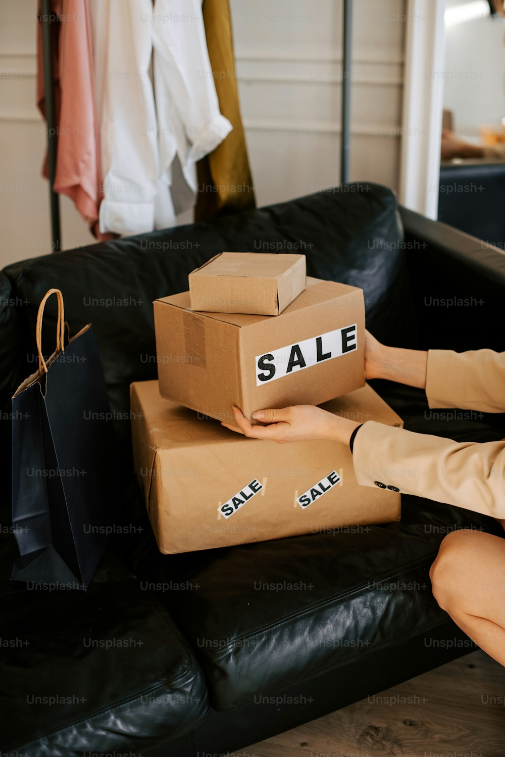 a woman sitting on a couch with boxes on her feet