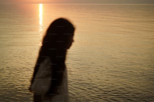 uma mulher em pé na frente de um corpo de água