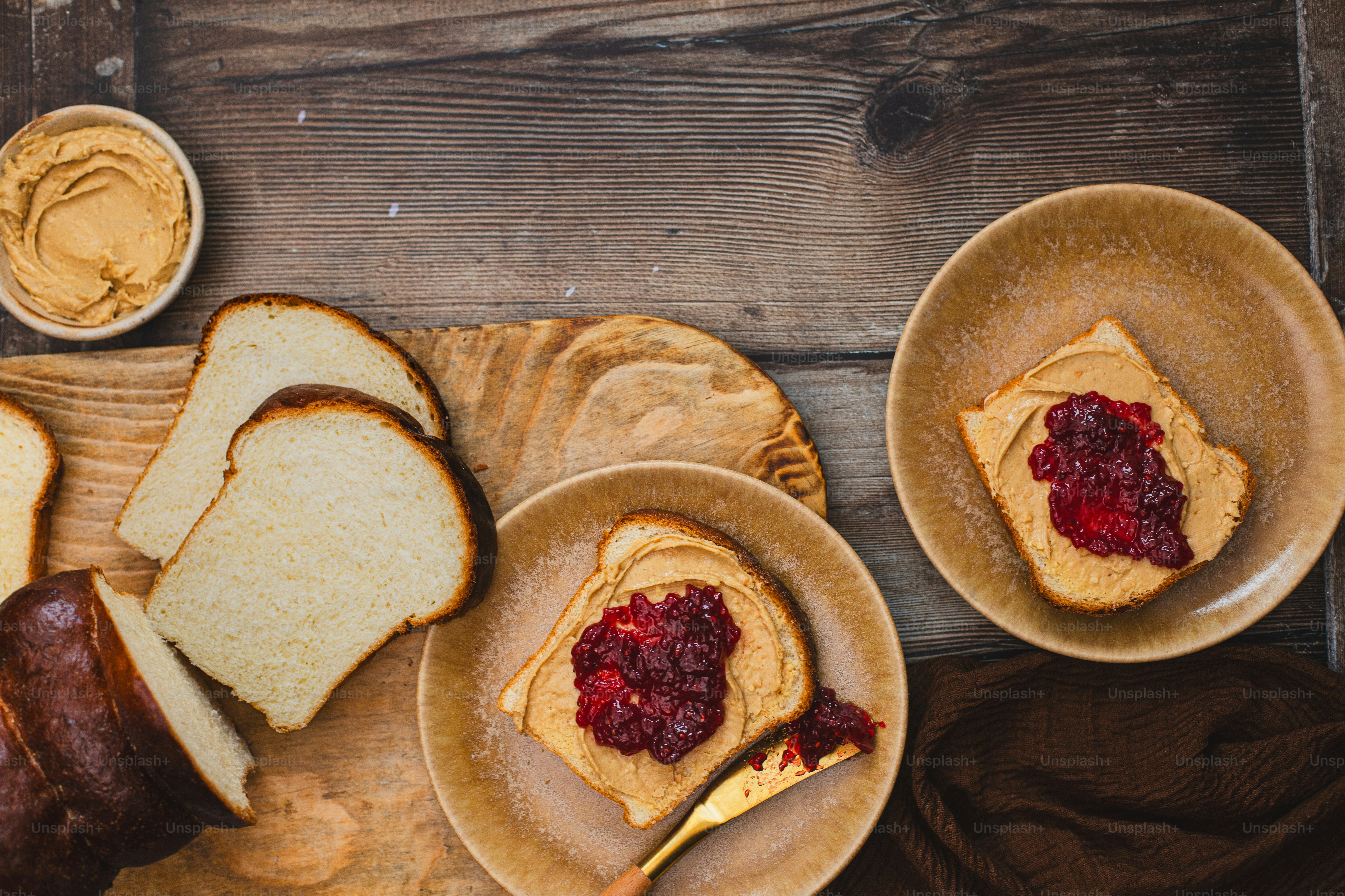 a table topped with two plates of bread and jelly