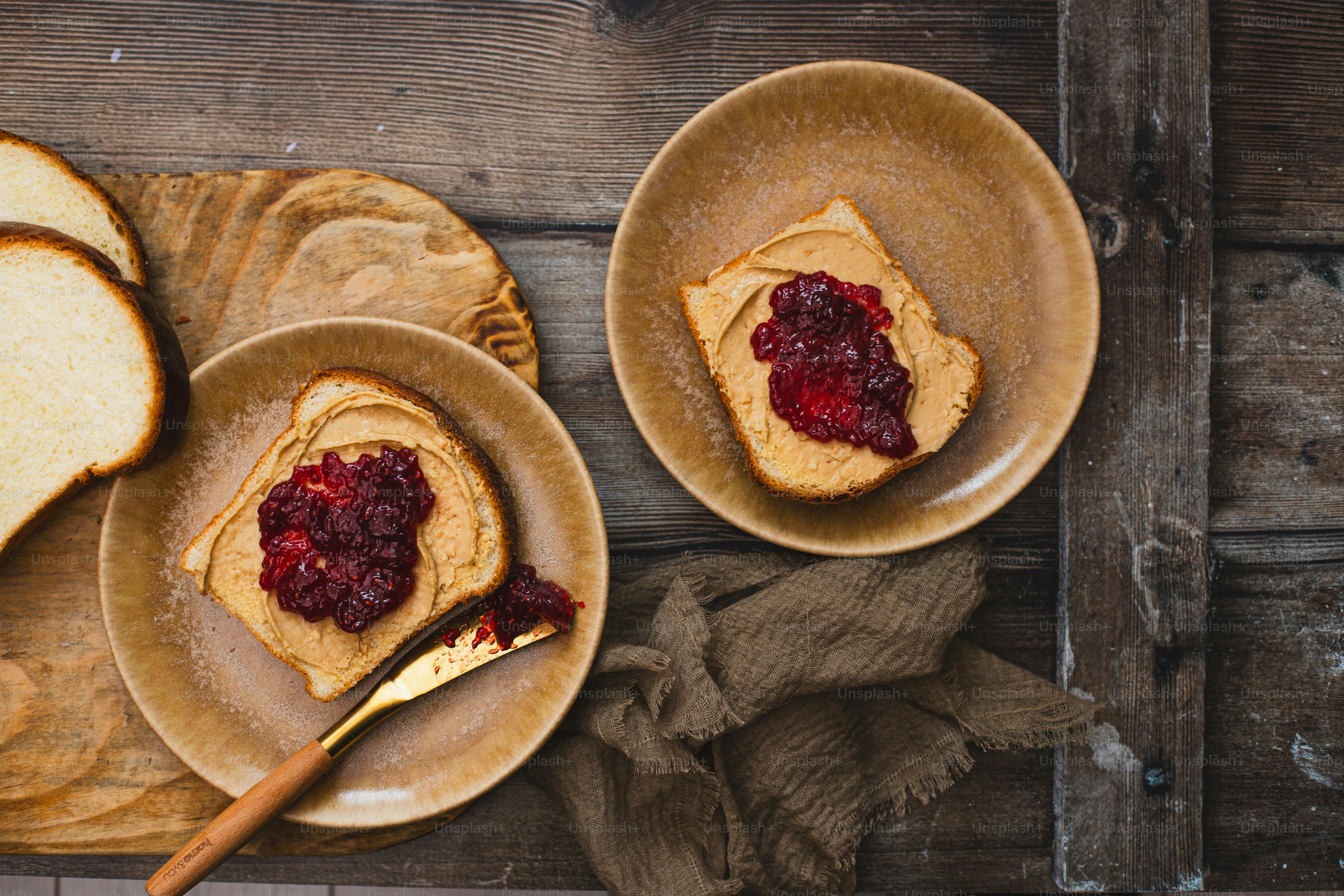 two plates with peanut butter and jelly on them
