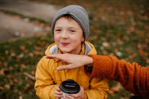 a little boy holding a coffee cup in his hands