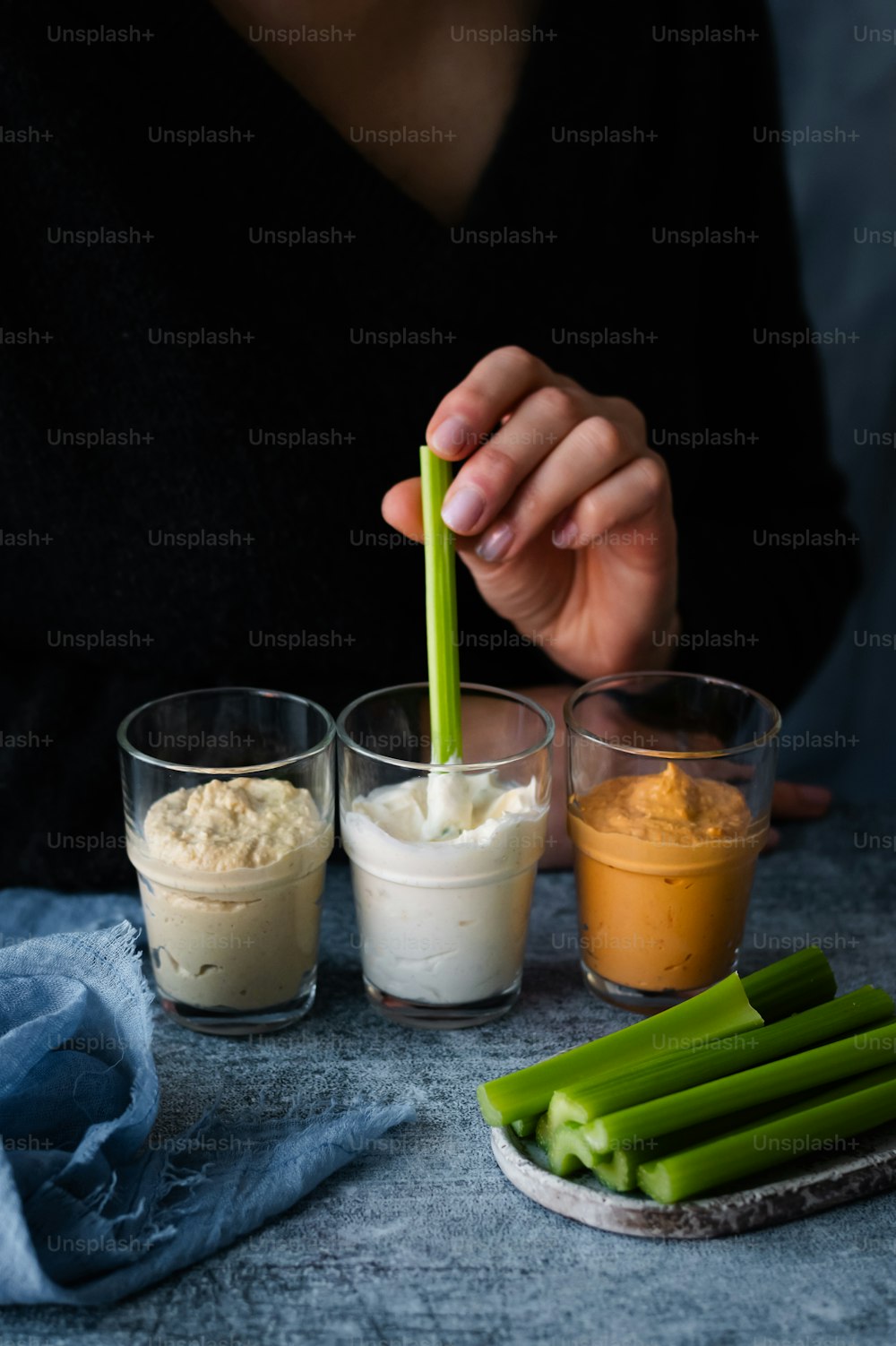 a person holding a green straw over a plate of food
