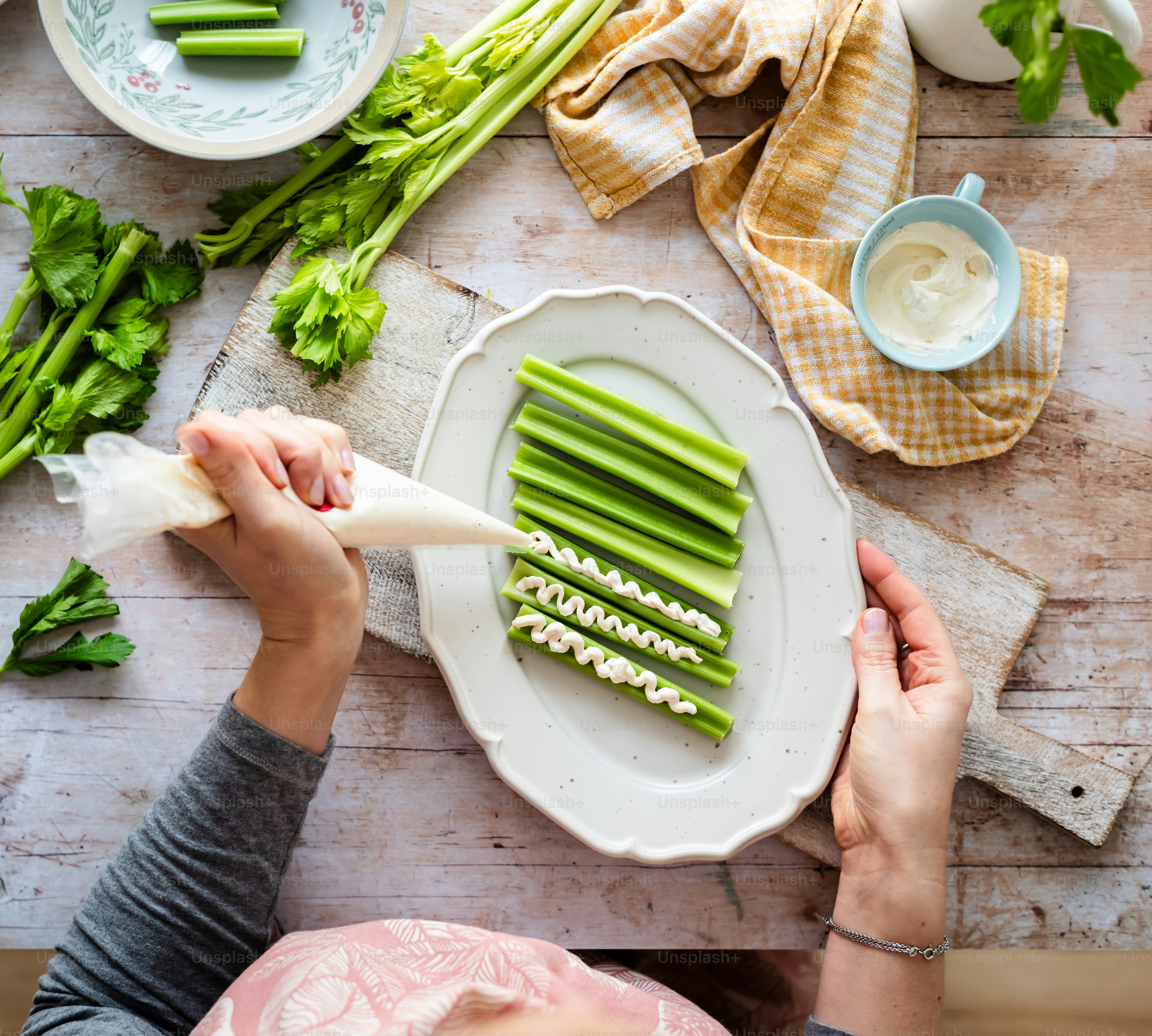 a person cutting celery on a white plate