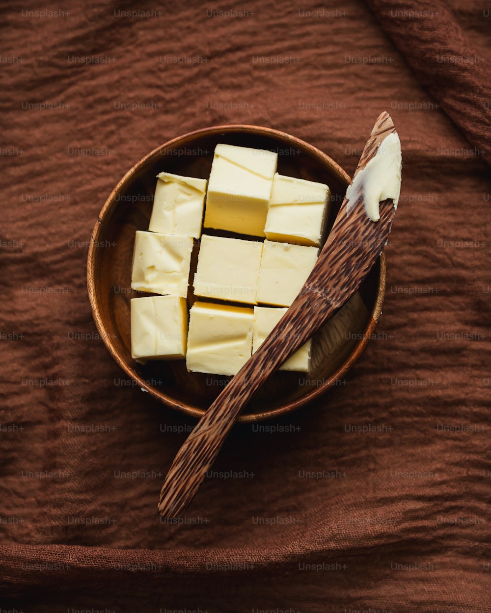 a bowl of tofu and chopsticks on a brown cloth