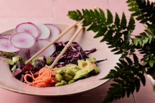 a bowl of vegetables and chopsticks on a table