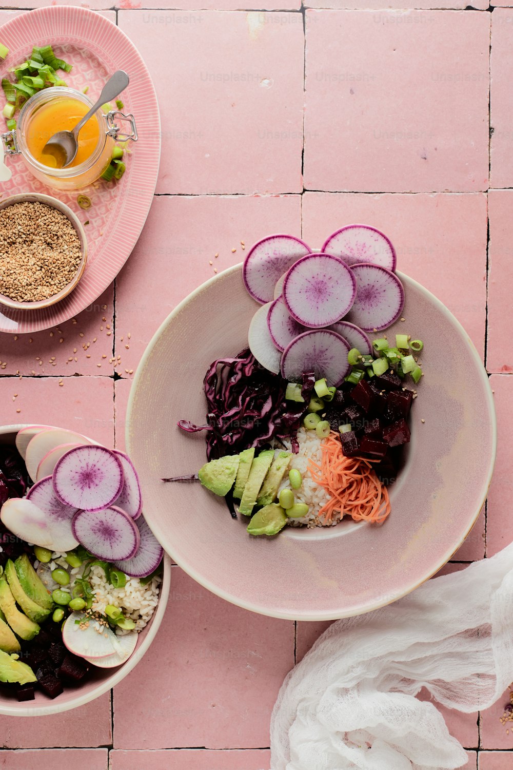 a pink table topped with two bowls filled with food