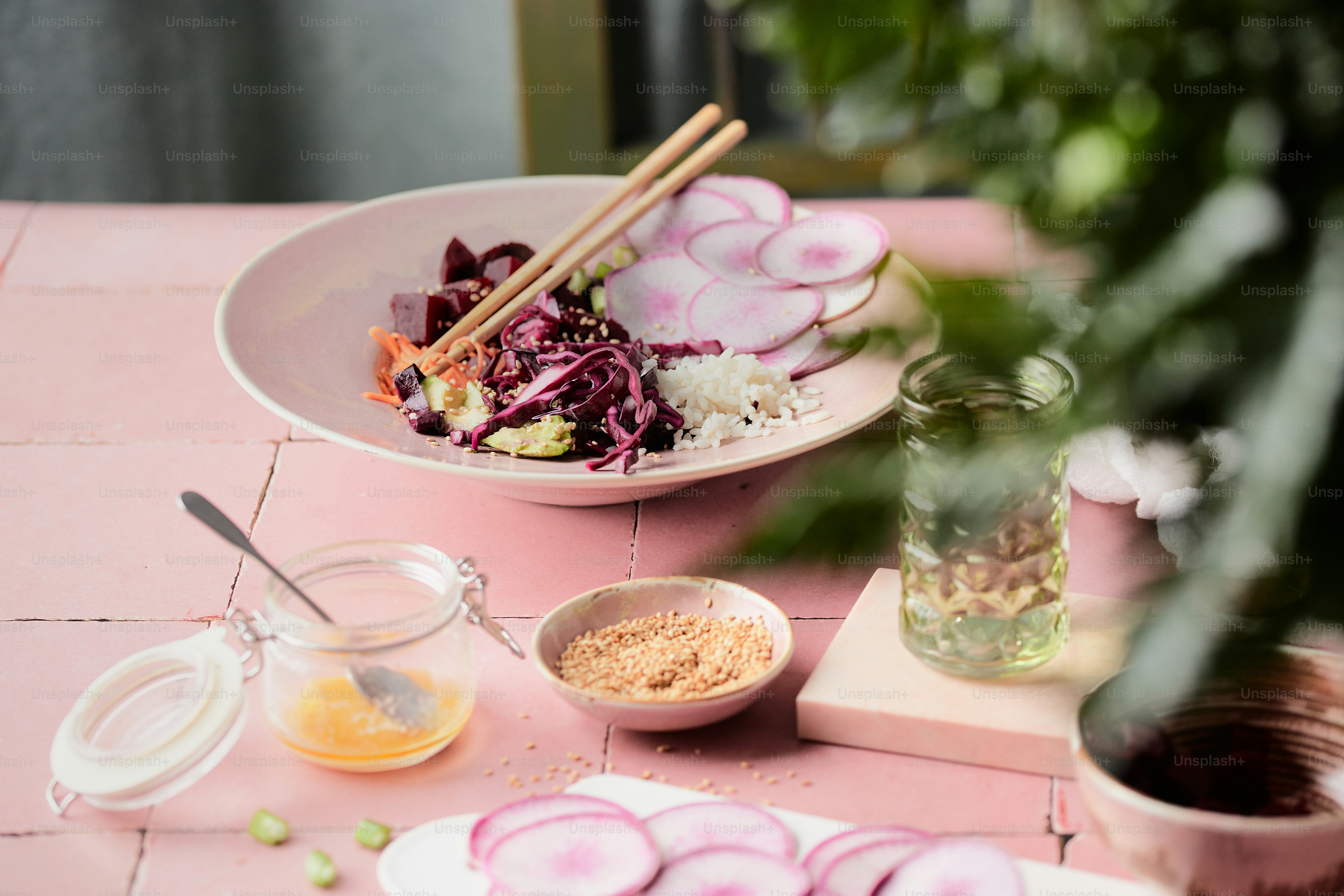 A pink table topped with plates of food photo – Vegan poke bowl Image ...