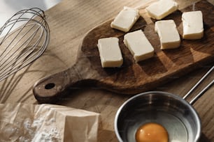uma tábua de corte de madeira coberta com pedaços de queijo