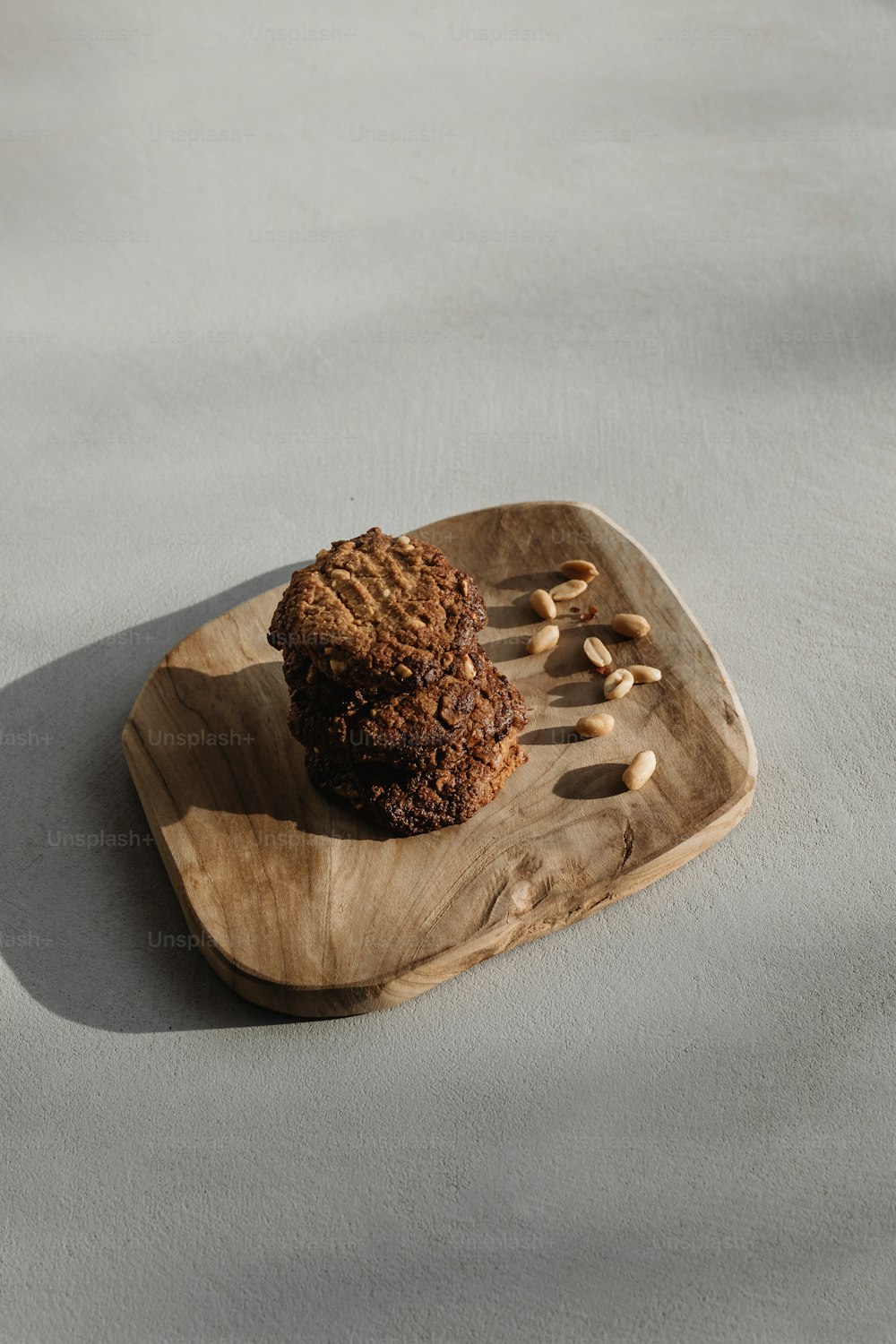 a cookie on a wooden plate with nuts