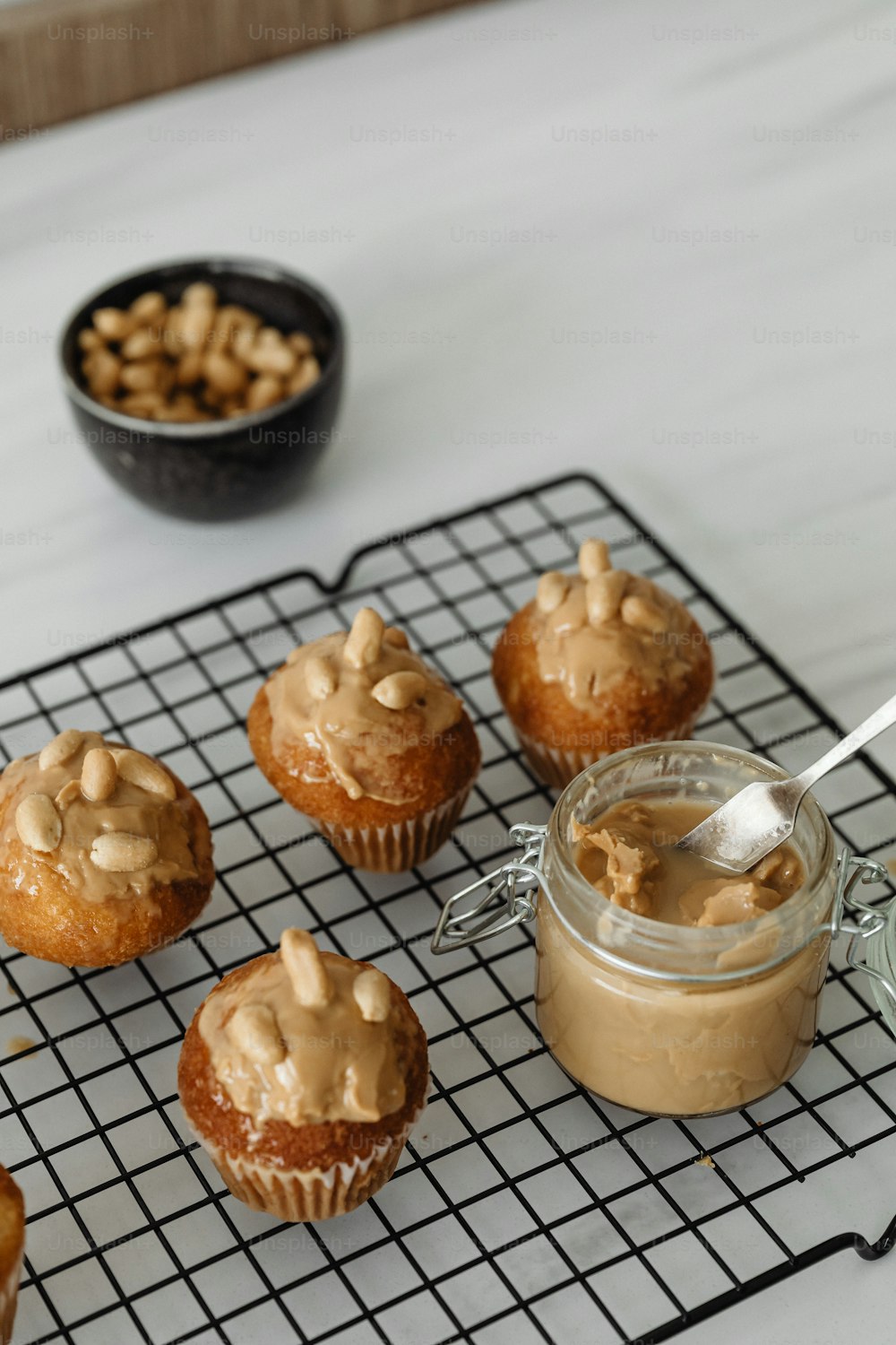 Cupcakes com cobertura de manteiga de amendoim em uma prateleira de resfriamento