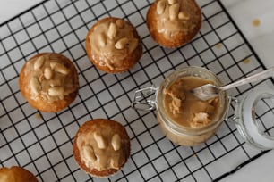 a jar of peanut butter next to some muffins