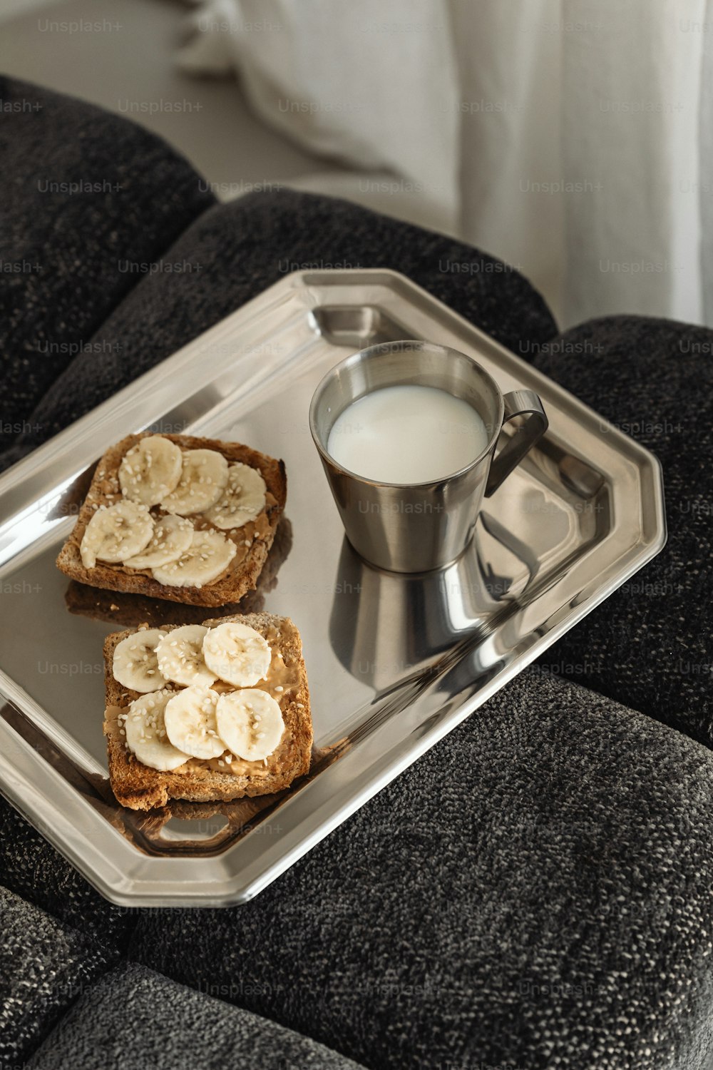 two pieces of bread and a cup of milk on a tray