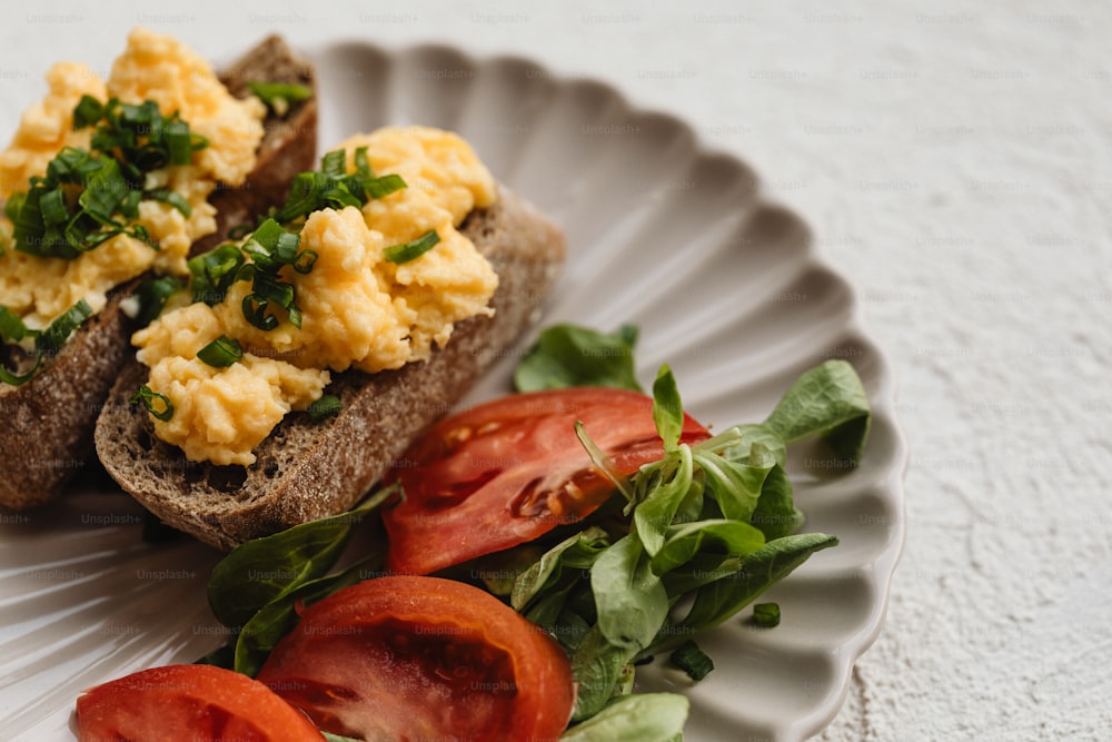 a white plate topped with two pieces of bread covered in scrambled eggs