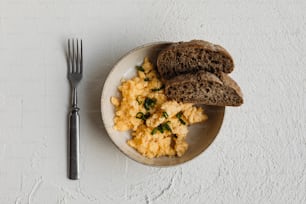 a white plate topped with eggs and toast next to a fork