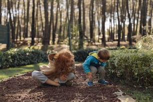 Duas crianças brincando com um ursinho de pelúcia em um parque