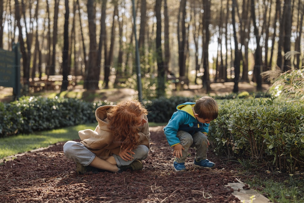 two children playing with a teddy bear in a park