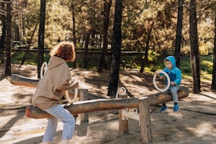 a little boy sitting on top of a wooden bench