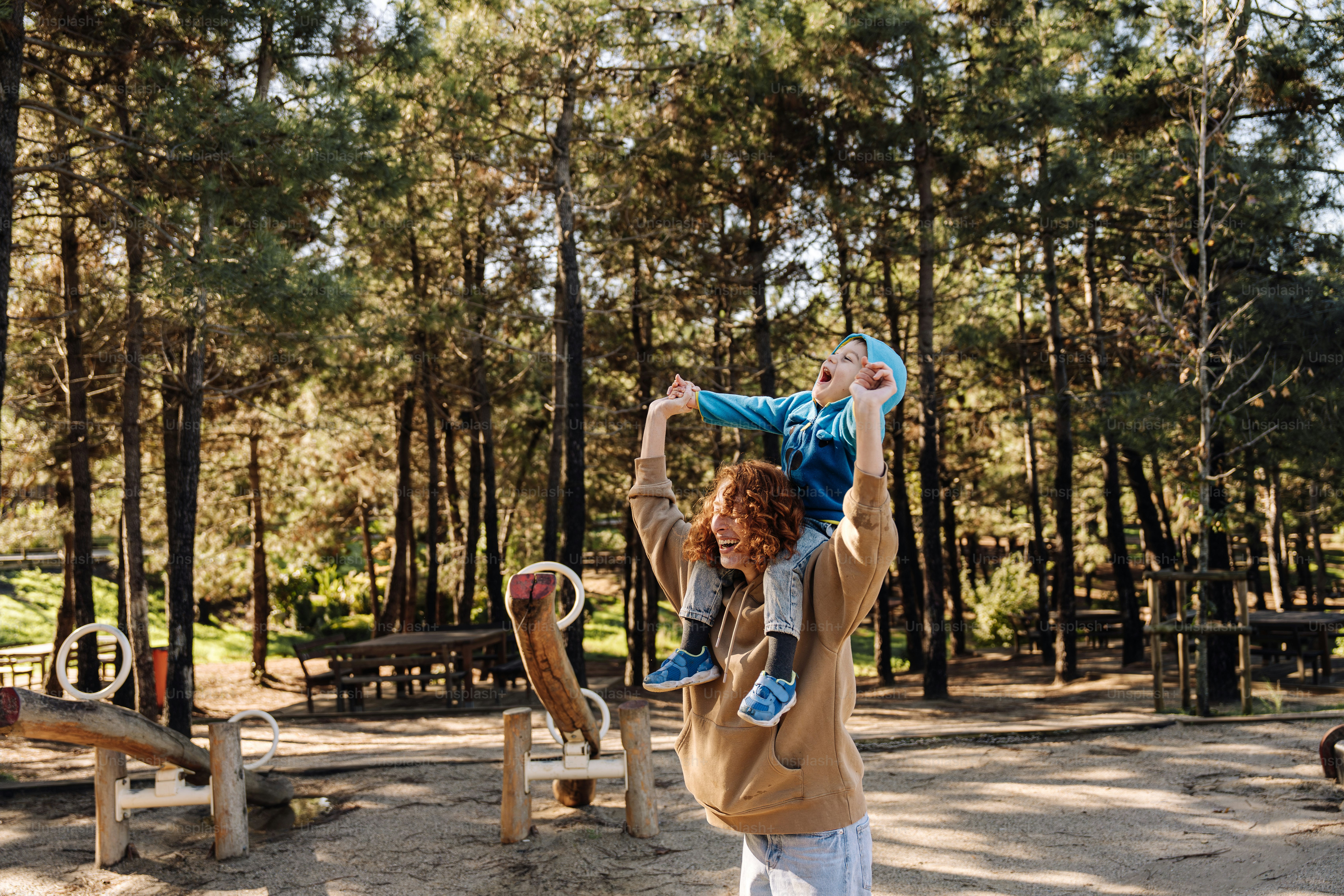 a woman holding a child in her arms in a park