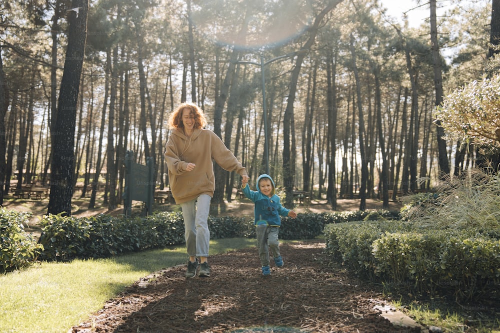 a woman and a child are walking in the woods