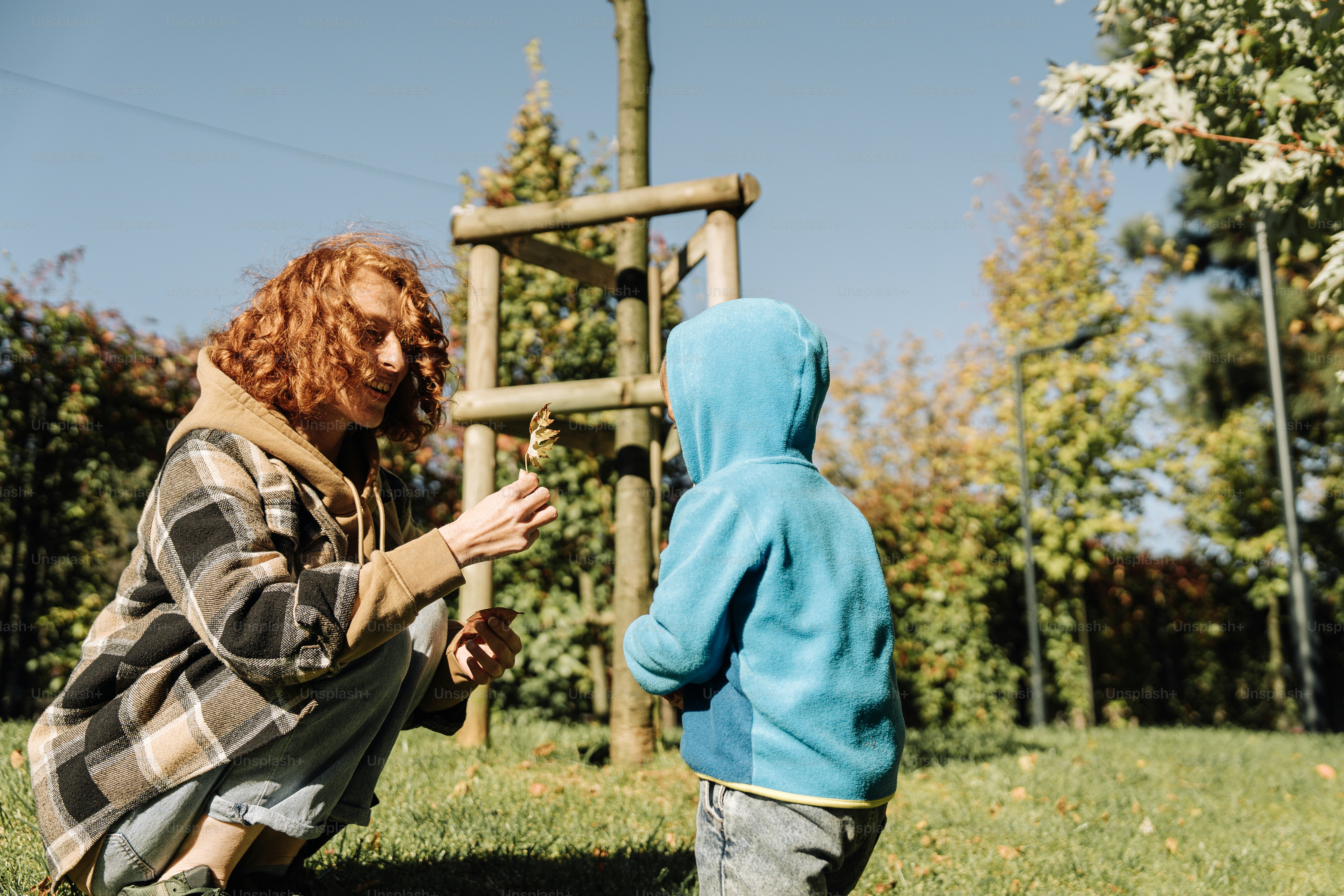 a woman kneeling down next to a child