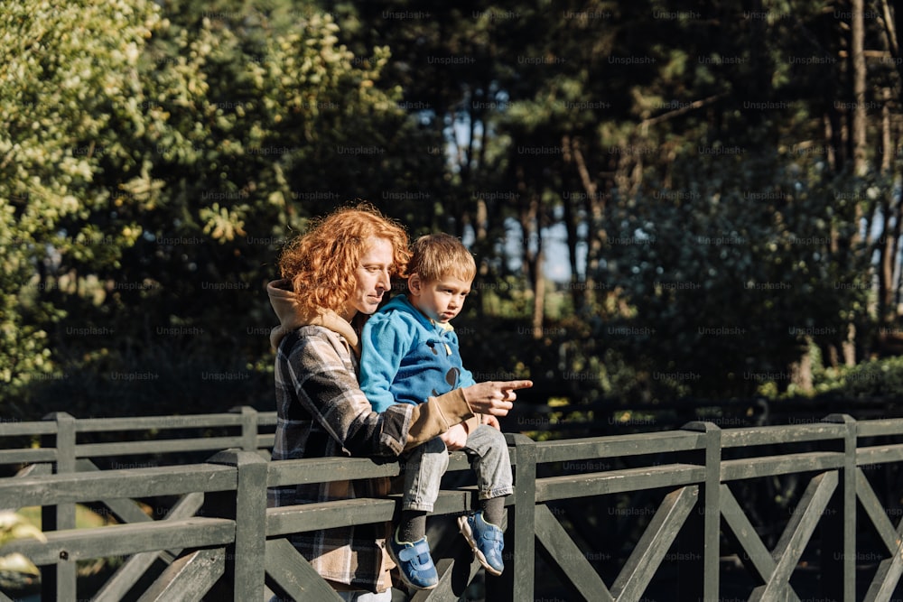 a woman and a child are looking at a cell phone