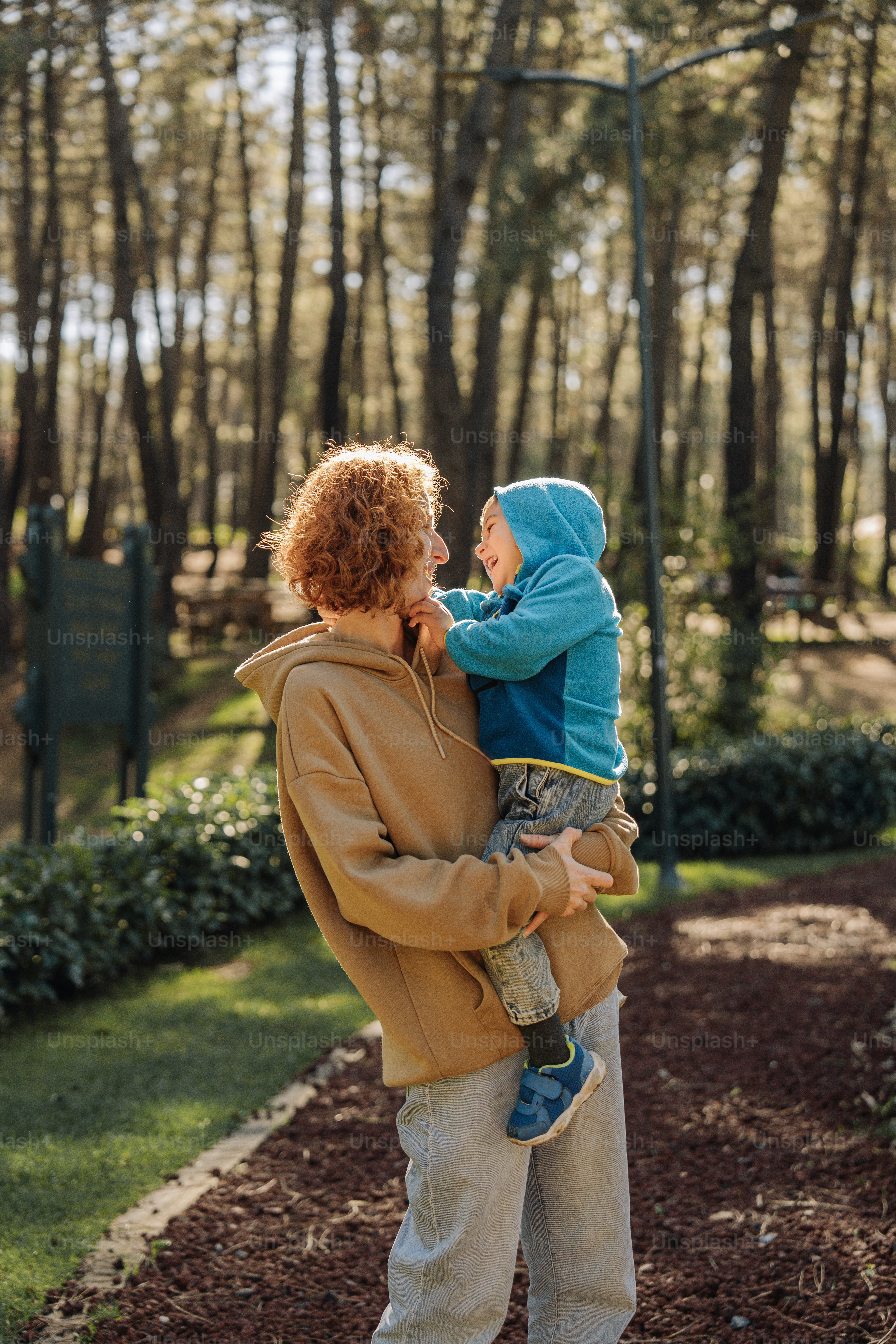 a woman holding a child in a park