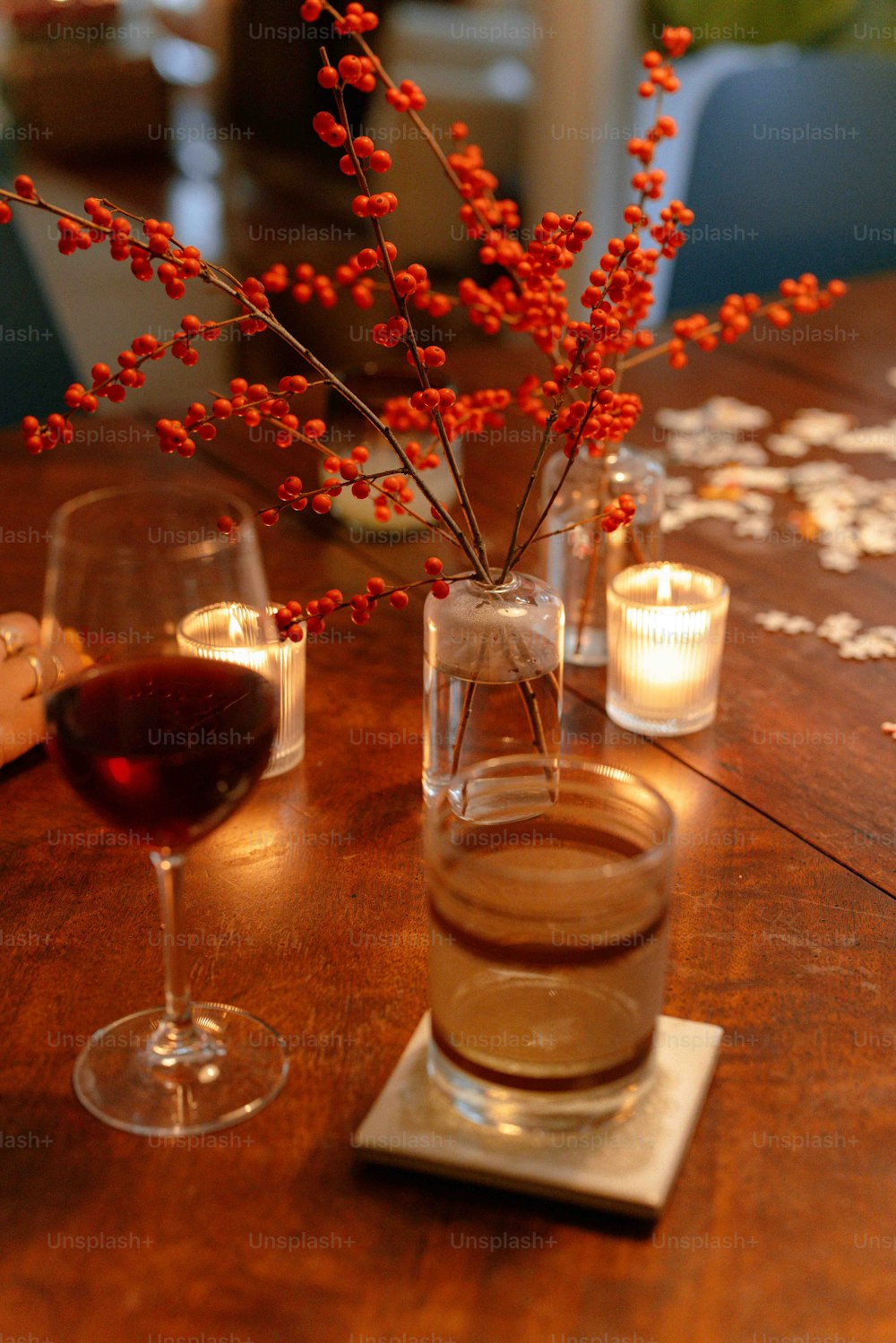 a wooden table topped with glasses of wine and a vase filled with flowers