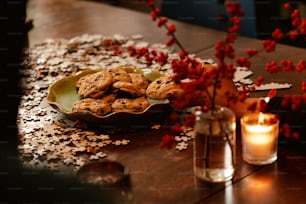 a table topped with a plate of cookies next to a candle