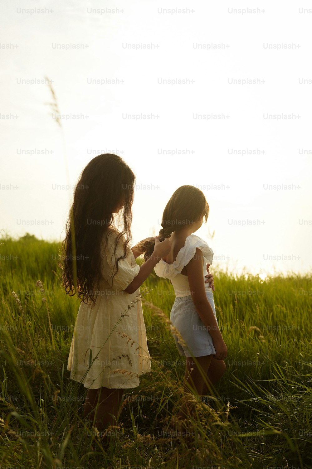 two little girls standing in a grassy field