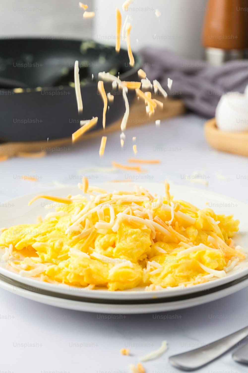 a plate of scrambled eggs with cheese sprinkled on top
