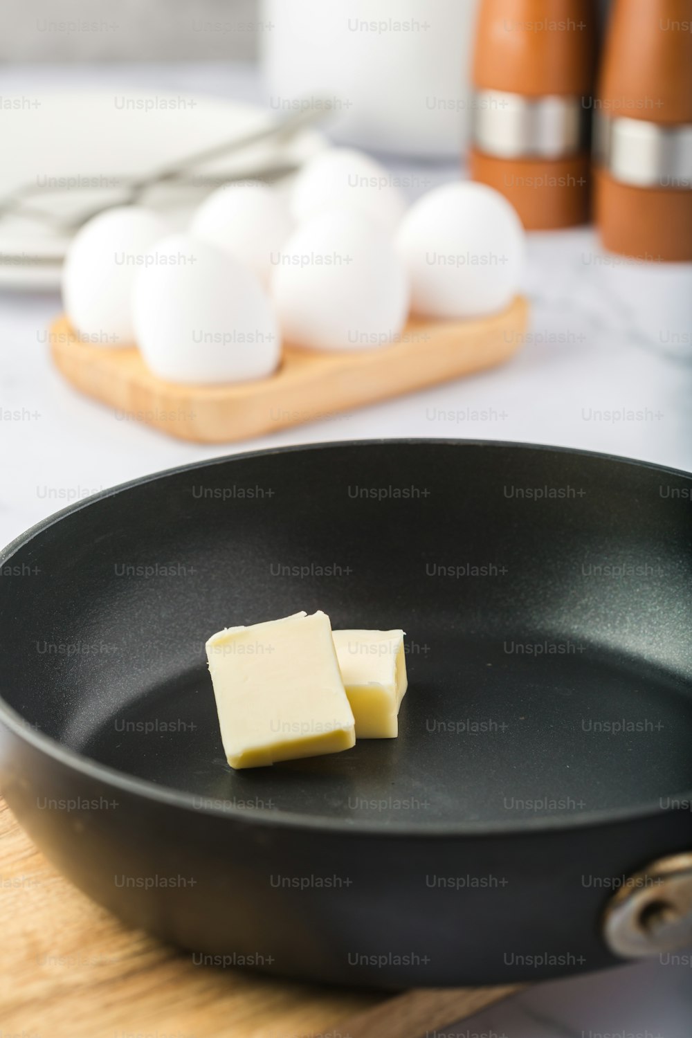 two pieces of butter sit in a frying pan