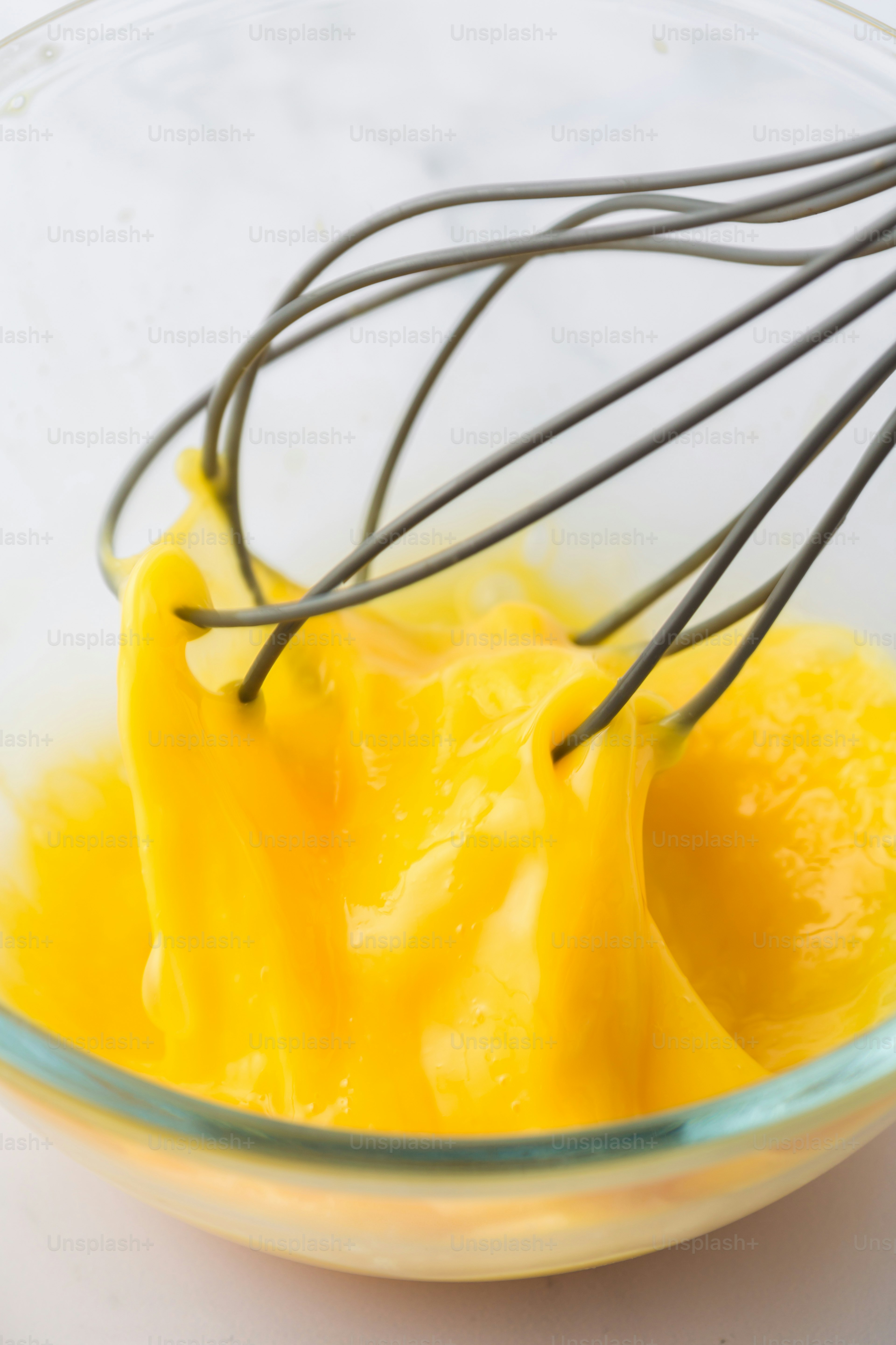 a glass bowl with a whisk in it