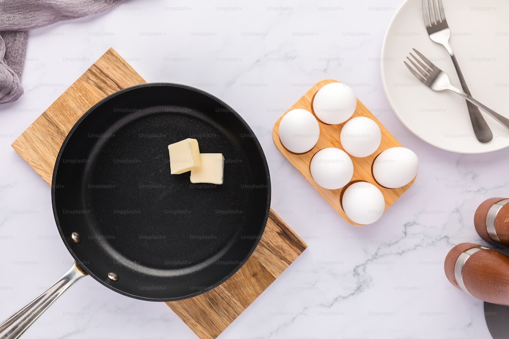 テーブルの上に卵とチーズが載った鍋